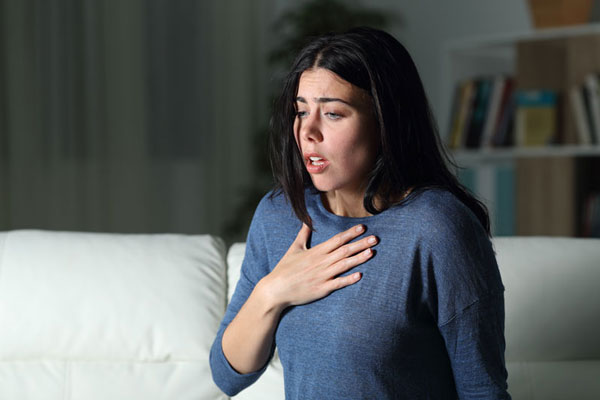 Anxious woman with hand on chest