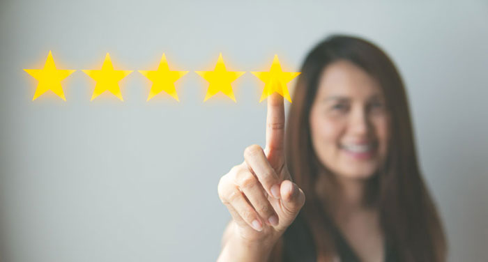 Woman pointing to five star review icons