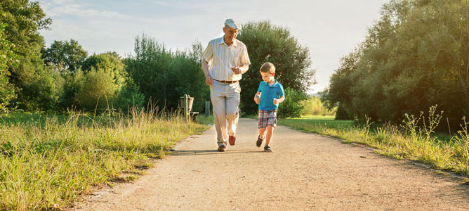 older man and child jogging down path